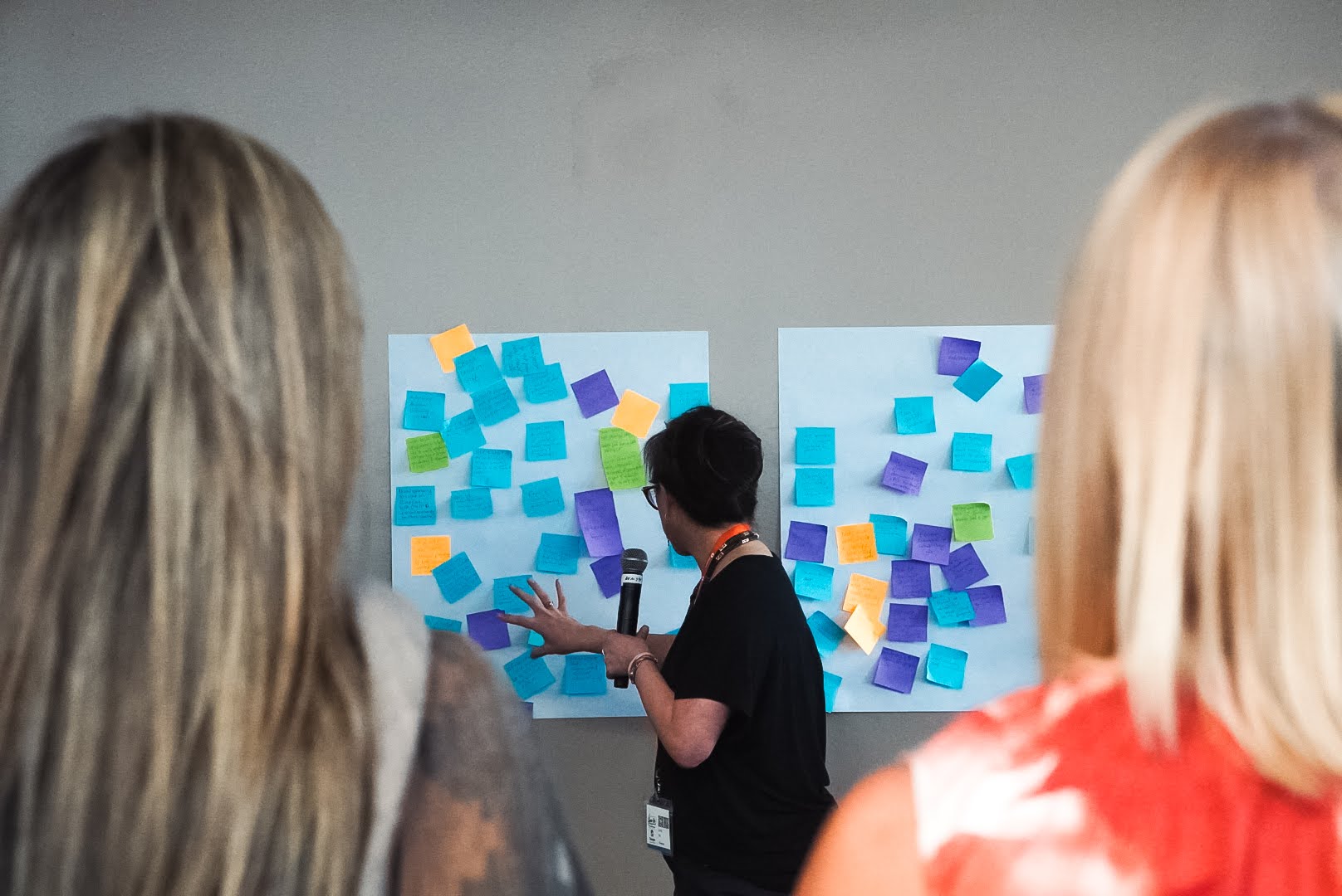 Facilitator reviewing collaborative sticky-note boards with participants